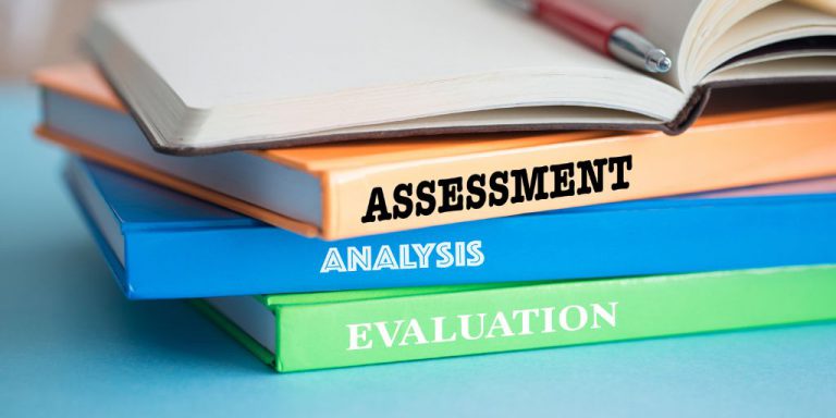 Pila de libros con las palabras "Assessment", "Analysis" y "Evaluation" en los lomos.